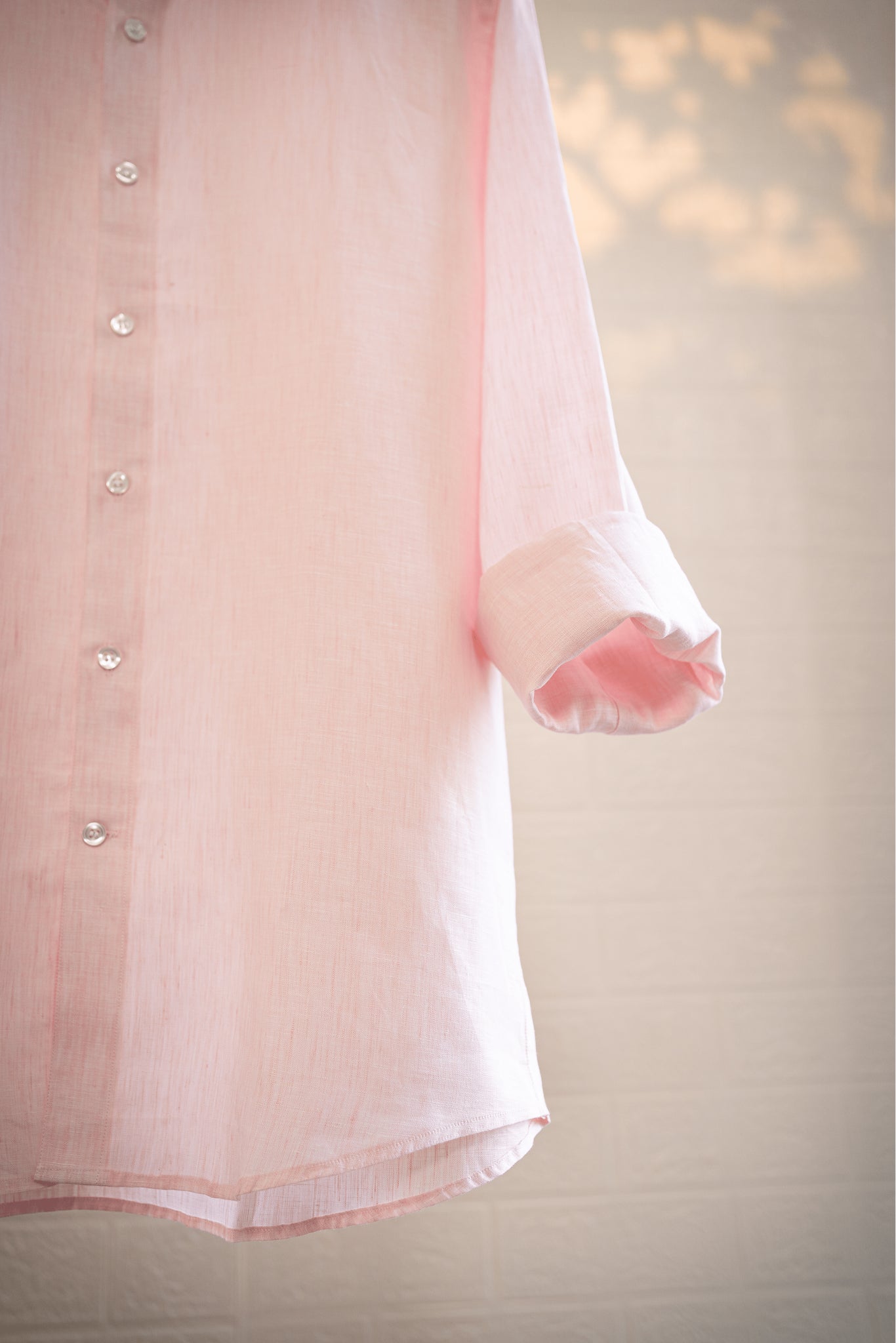Blush / Light pink shirt with rolled-up sleeves on a neutral background