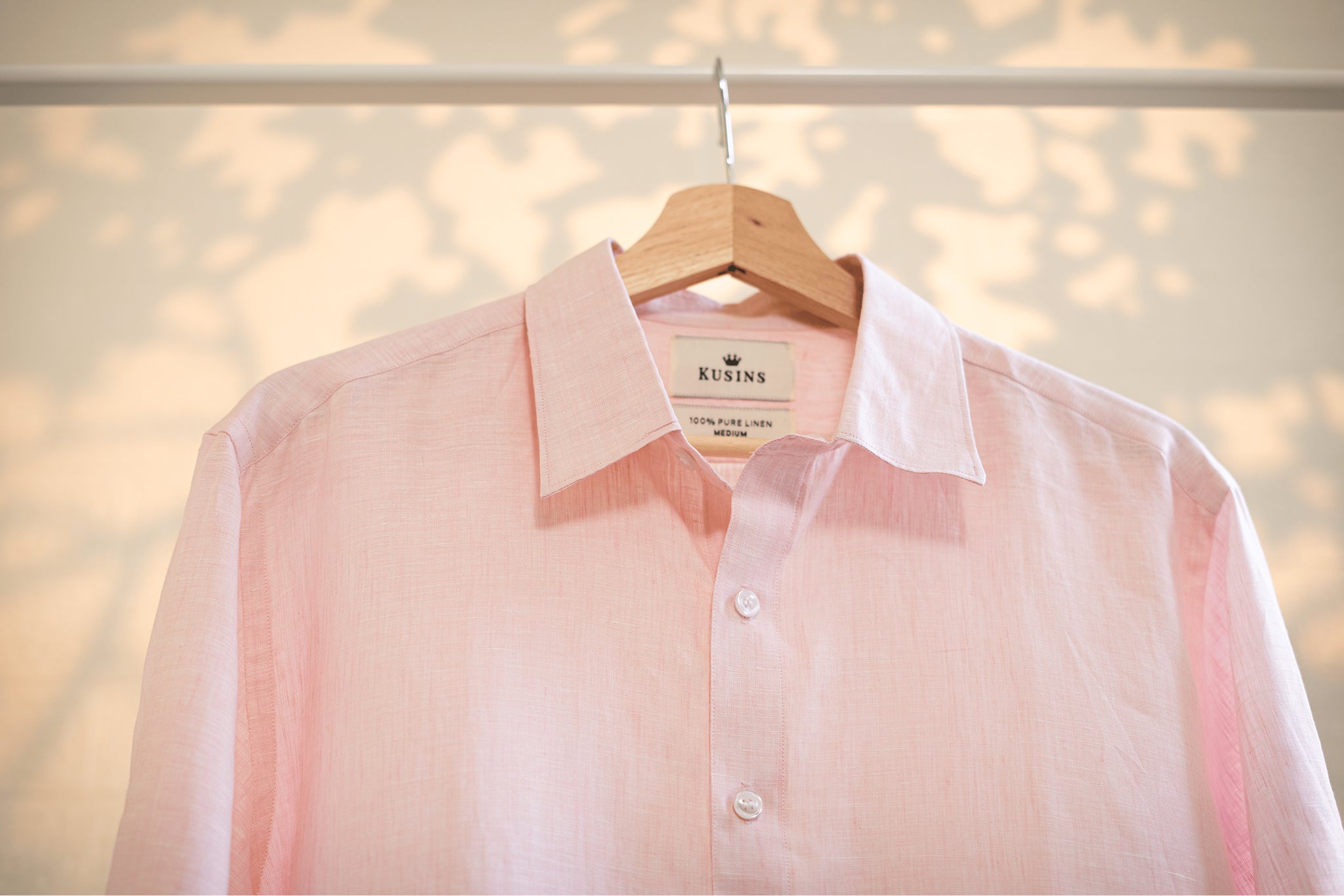 Blush / Pink shirt on a hanger with a blurred background