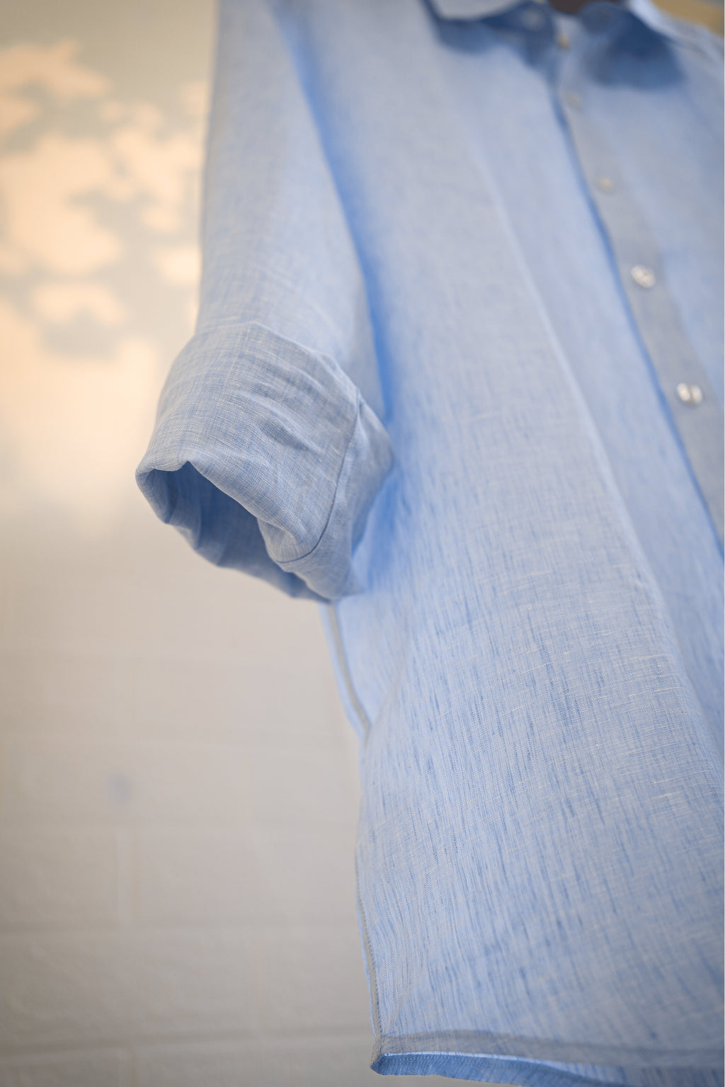 Ocean / Light blue shirt with rolled-up sleeve on a plain background