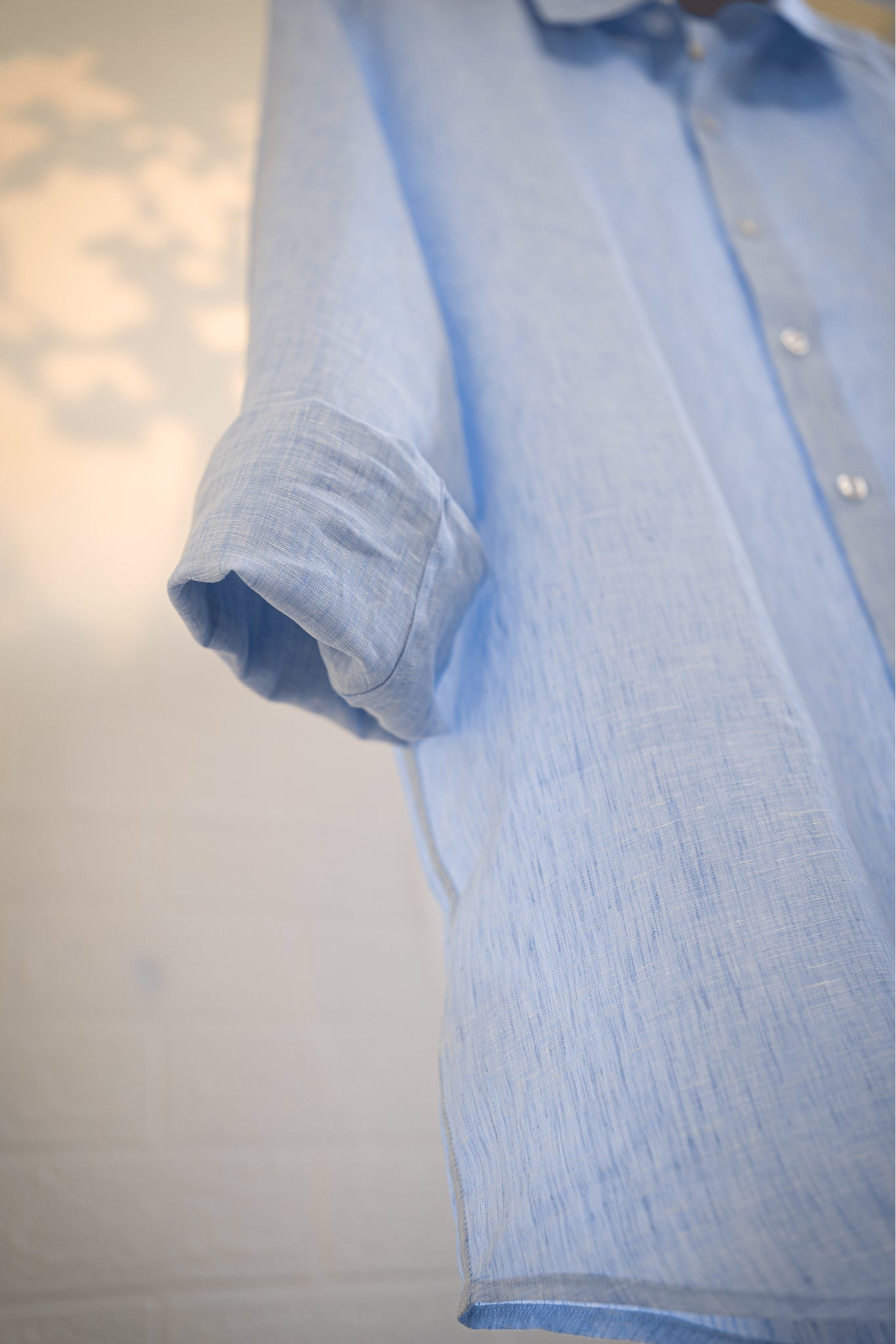 Ocean / Light blue shirt with rolled-up sleeve on a plain background