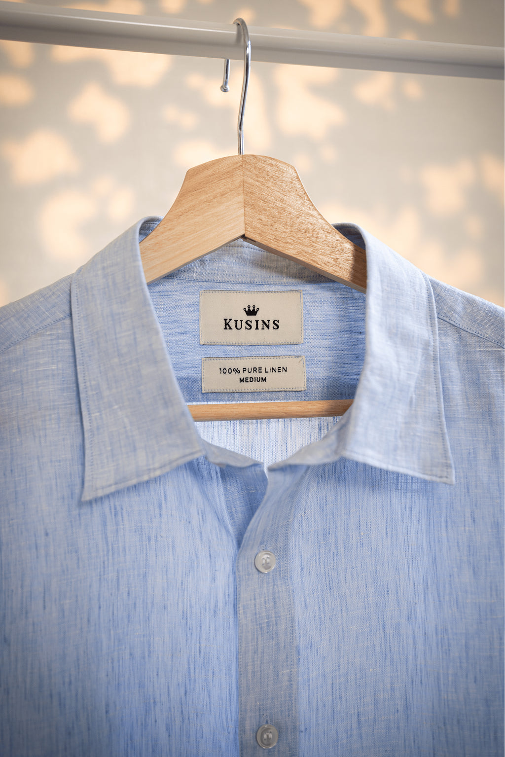 Ocean / Blue shirt on a hanger with 'Kusins' label