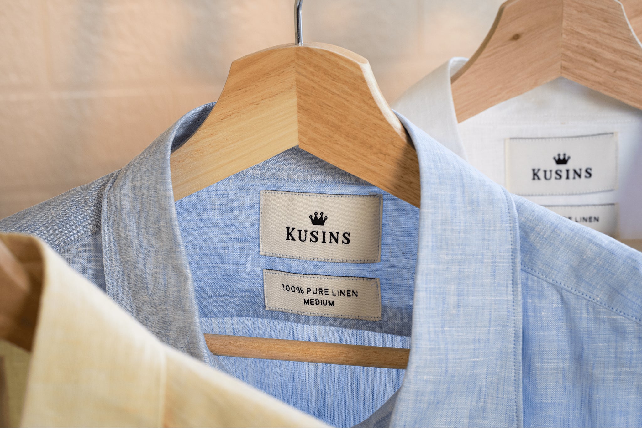 Ocean / Blue linen shirt on a hanger with 'Kusins' branding.