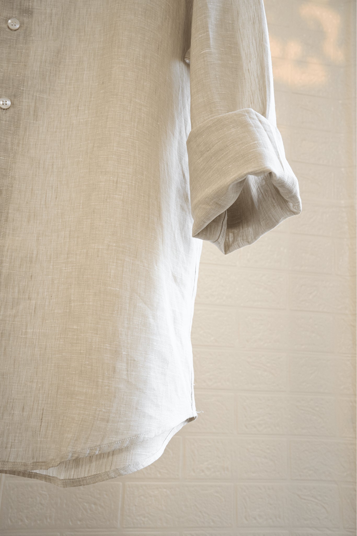 Sand / Beige linen shirt with rolled-up sleeves on a neutral background