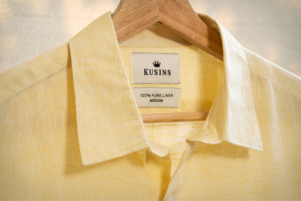 Summer / Yellow linen shirt on a hanger with 'Kusins' label