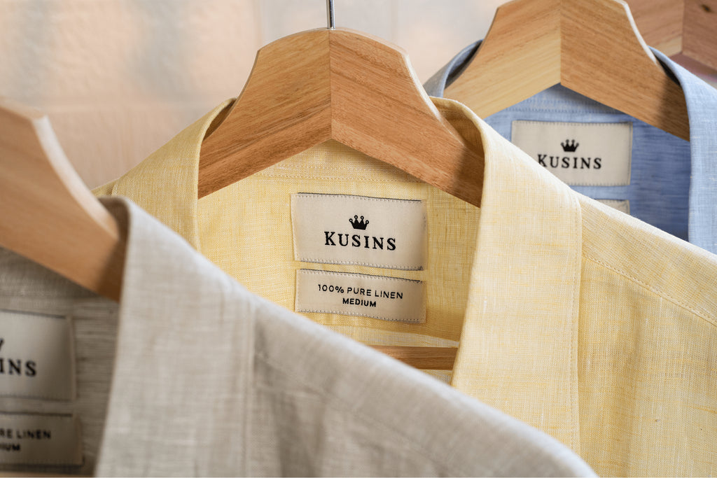 Summer linen shirt on hanger with 'Kusins' brand labels displayed.