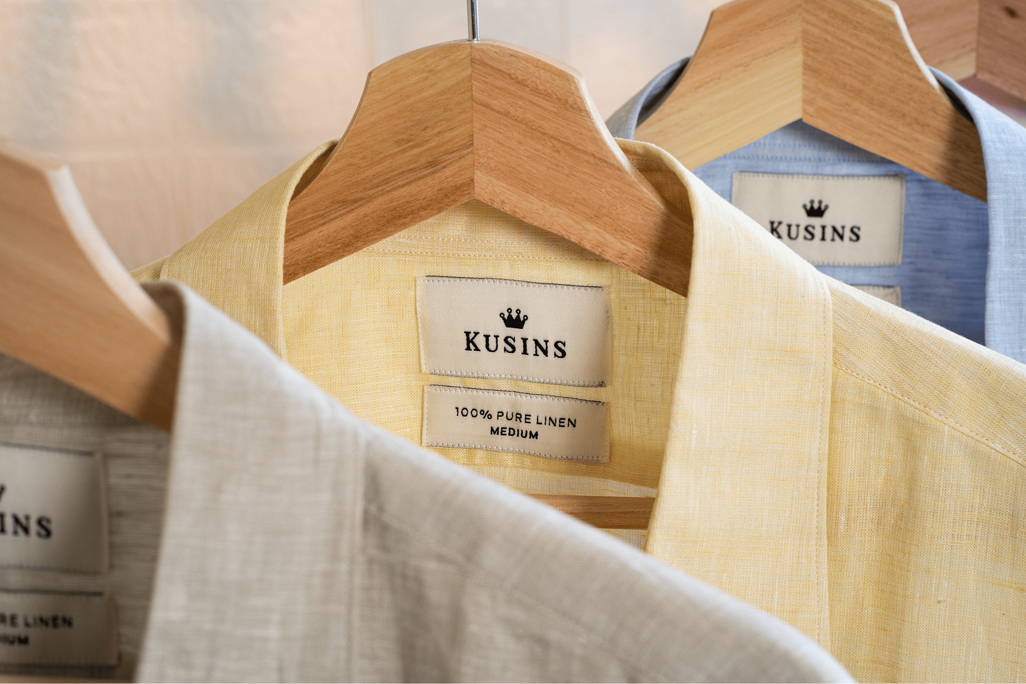 Summer linen shirt on hanger with 'Kusins' brand labels displayed.