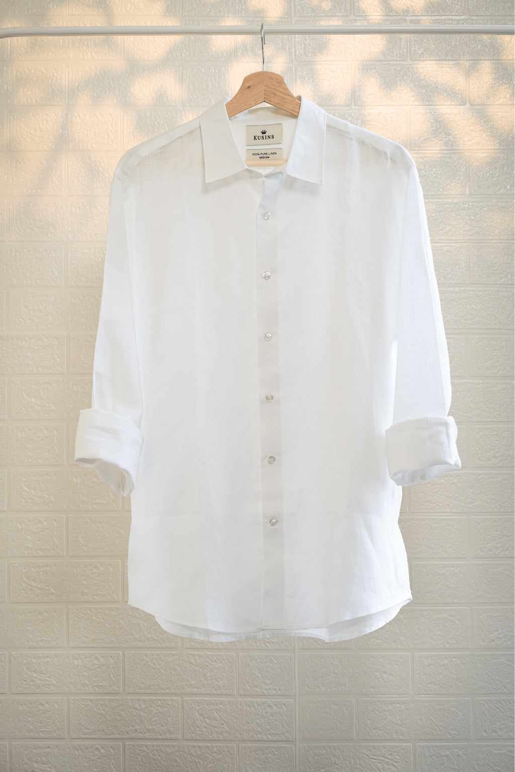 chalk or White shirt on a hanger against a light background