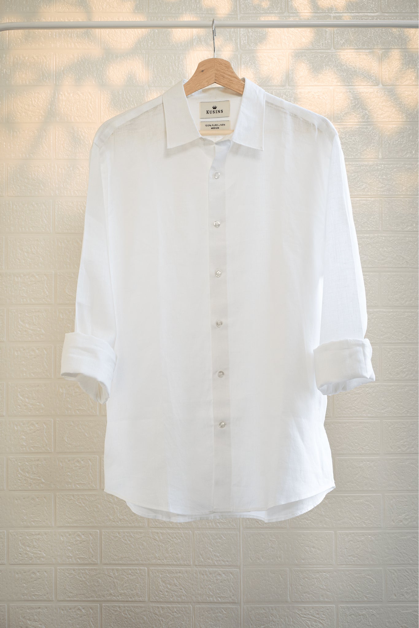 chalk or White shirt on a hanger against a light background
