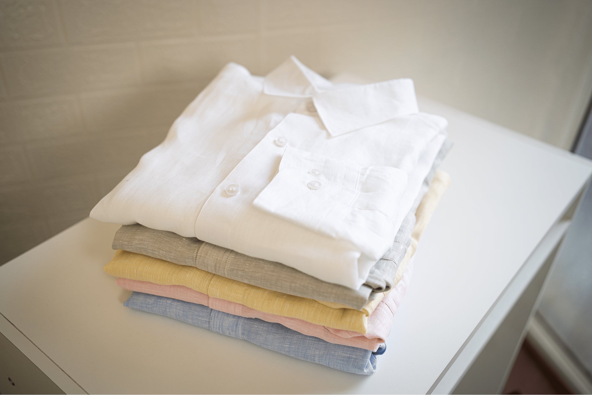 Stack of folded shirts with chalk shirt on the top 