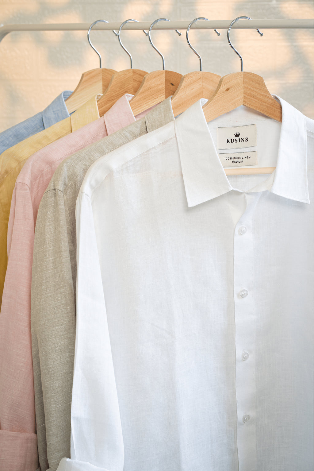 chalk or White shirt on a hanger with other shirts in the background